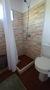 uma casa de banho com um WC branco e um chuveiro em Adorable microcasa a 4km del centro de Maldonado y de playa mansa, en barrio muy tranquilo! em Maldonado