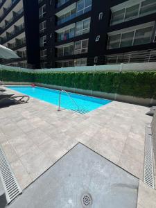 a swimming pool in front of a building at Apartamento en Santiago centro cerca de movistar arena, caupolican in Santiago