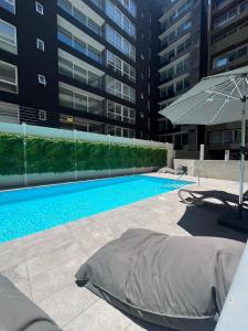 a swimming pool in front of a building at Departamento en Santiago centro cerca de movistar arena, Caupolican in Santiago