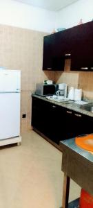 a kitchen with a counter and a white refrigerator at Angel Appartement in Marrakesh