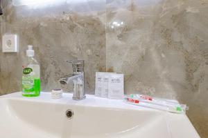a bathroom sink with a toothbrush and a bottle of soap at Apple City Apartments -161, ЭКСПО, Mega Silky Way in Prigorodnyy +14 photos
