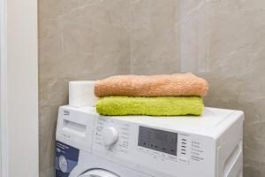 a stack of towels on top of a washing machine at Apple City Apartments -161, ЭКСПО, Mega Silky Way in Prigorodnyy