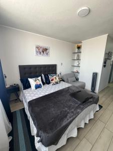 um quarto com uma cama grande e um cobertor preto em Apartamento en Santiago centro cerca de movistar arena, caupolican em Santiago