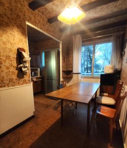 a dining room with a wooden table and a refrigerator at Sci LS in Fresnes