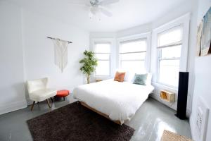 a white bedroom with a bed and a chair at 5 Bedroom Holiday Getaway Museums Galleries in Detroit