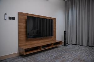 una TV a schermo piatto seduta sopra un centro di intrattenimento di شقة فندقية Elite Corner a Riyad