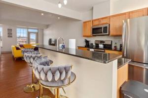 a kitchen with bar stools and a counter top at Corporate Housing by MGM in Detroit