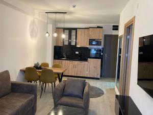 a living room and kitchen with a table and a couch at Pogled Apartman Kopaonik in Kopaonik