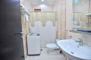 a bathroom with a toilet and a sink and a shower at Aseel Alsharq Hotel in Riyadh