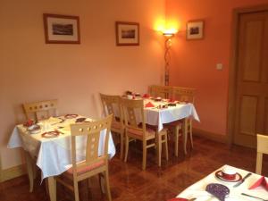 un comedor con 2 mesas y sillas y una luz en Anvil House, en Achill Sound