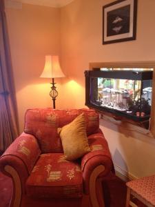 a living room with a red couch and a tv at Anvil House in Achill Sound