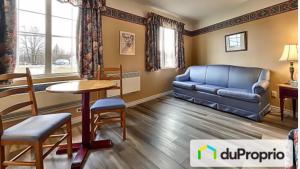 a living room with a couch and a table at Hôtel Le Portneuvois in Portneuf