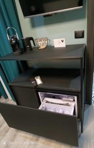 ein schwarzes Regal mit offener Schublade in einem Raum in der Unterkunft Blu room in Taranto
