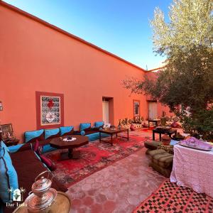 eine Terrasse mit Sofas und Tischen in einem Gebäude in der Unterkunft Dar Toda - Zagora guest house in Zagora