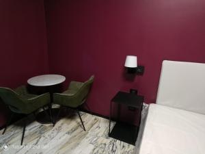 Zimmer mit einem Bett, 2 Stühlen und einem Tisch in der Unterkunft Blu room in Taranto