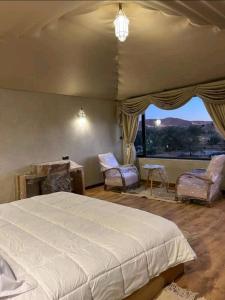 ein Schlafzimmer mit einem großen Bett und einem großen Fenster in der Unterkunft كعب غزال in Merzouga