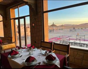 a table in a restaurant with a view of the desert at كعب غزال in Merzouga