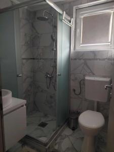 a bathroom with a shower with a toilet and a sink at Villa with mountain view in Gevgelija