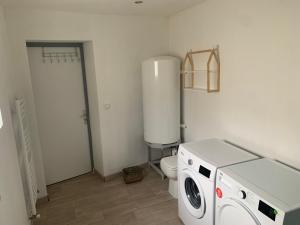ein Badezimmer mit einem WC, einer Waschmaschine und einem Trockner in der Unterkunft Logement entier 100m2 in Sin-le-Noble