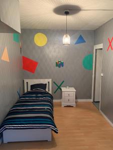 Schlafzimmer mit einem Bett und farbenfrohen Wänden in der Unterkunft Logement entier 100m2 in Sin-le-Noble