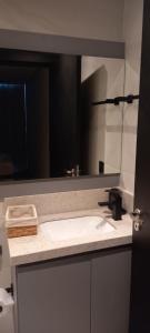 eine Badezimmertheke mit einem Waschbecken und einem Spiegel in der Unterkunft Apartamento You Canela 207 in Canela