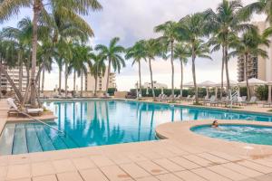 una piscina con palmeras y una persona nadando en ella en Amazing Four Seasons Resort With Great View, en Miami