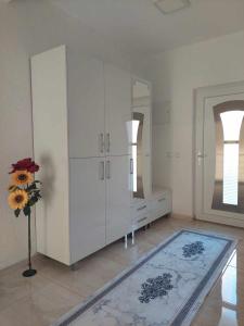 a room with a white cabinet and a vase of flowers at Villa with mountain view in Gevgelija