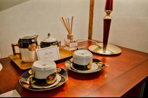 a table with two tea pots and plates on it at HOTEL ELSA in Skopje