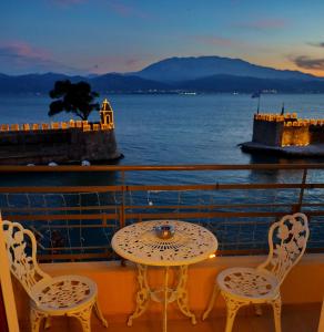 a table and chairs on a balcony with a view of the water at Vip Lepanto Port Suites in Nafpaktos