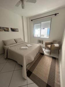 1 dormitorio con 1 cama, 1 silla y 1 ventana en Apartamento em Santos no Gonzaga em frente a praia en Santos