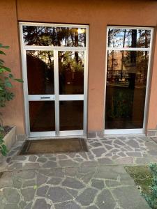 un ingresso a una casa con porte in vetro di Appartamento brevi periodi "Pedrini's Welcome Home" a Bergamo