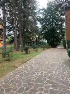 a cobblestone path in a park with trees at Appartamento brevi periodi "Pedrini's Welcome Home" in Bergamo