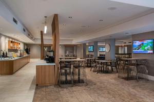 a lobby with tables and bar stools and a tv at SpringHill Suites by Marriott New Orleans Warehouse Arts District in New Orleans