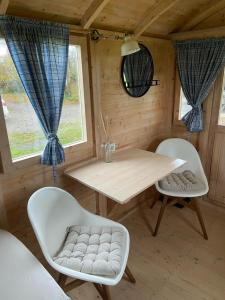 Habitación de madera con mesa y 2 sillas en Pipowagen op Camperplaats Vechtdal, en Nieuwleusen
