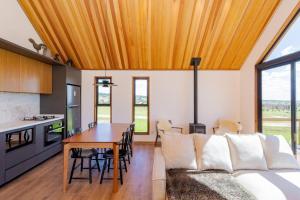 a kitchen and living room with a couch and a table at Cabanas Purunã in Balsa Nova