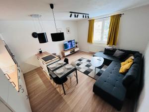 a living room with a black couch and a table at Nordic House in Závažná Poruba