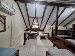 Pokój wieloosobowy z sufitem z drewnianymi belkami stropowymi w obiekcie Chalé Carvalho - Azul w mieście Itapoá