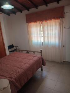 1 dormitorio con 1 cama con manta roja y ventana en CASA Don Manuel en Miramar