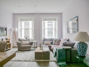 een woonkamer met een bank en 2 stoelen bij Exceptional apartment in the most desirable street in Londen