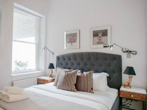 a bedroom with a large bed with striped pillows at Exceptional apartment in the most desirable street in London