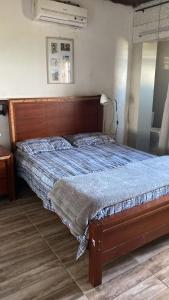 uma cama com uma cabeceira em madeira num quarto em Rancho Mateus! em Gravatá