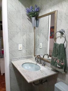 uma casa de banho com um lavatório e um espelho em Apartamento Copacabana Posto 5 no Rio de Janeiro