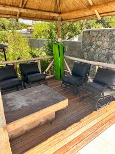 una terraza con 4 sillas y un cubo de basura verde en Wayta “Casa de campo” en San Fernando del Valle de Catamarca