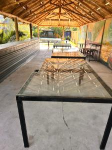 una gran mesa de madera en un pabellón con bancos en Wayta “Casa de campo” en San Fernando del Valle de Catamarca
