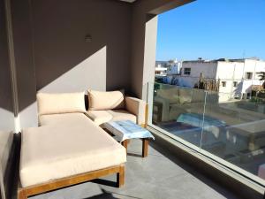 a living room with a couch and a window at Appartement haut standing in Essaouira