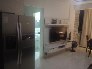 uma cozinha com frigorífico e uma televisão em 2 quadras do mar em Vila Velha