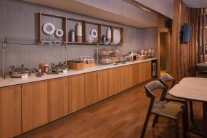 una cocina con armarios de madera, mesa y sillas en SpringHill Suites Herndon Reston, en Herndon
