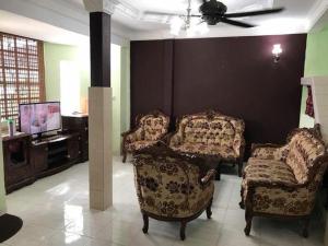 sala de estar con 2 sillas y TV en Homestay DI Kota Samarahan, en Kota Samarahan
