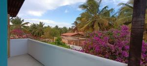 uma vista da varanda de um resort com flores roxas em Casa Tudo Azul em Amontada