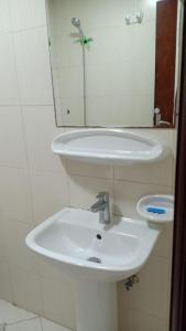 a bathroom with a white sink and a mirror at 22 R4 Single 1 small room in a 4-bedroom apartment with attached bathroom suitable for one person ### 22 R4 1 غرفة صغيرة في شقة مكونة من 4 غرف نوم مع حمام ملحق مناسبة لشخص واحد in Ajman 
